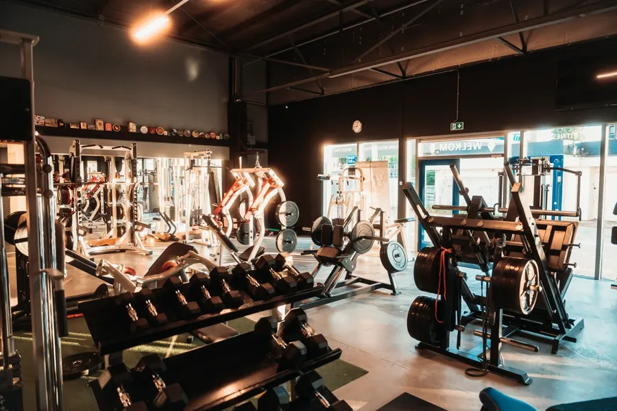 Dumbbellrek en halterbanken in de krachtruimte van De Sportschool Emmen